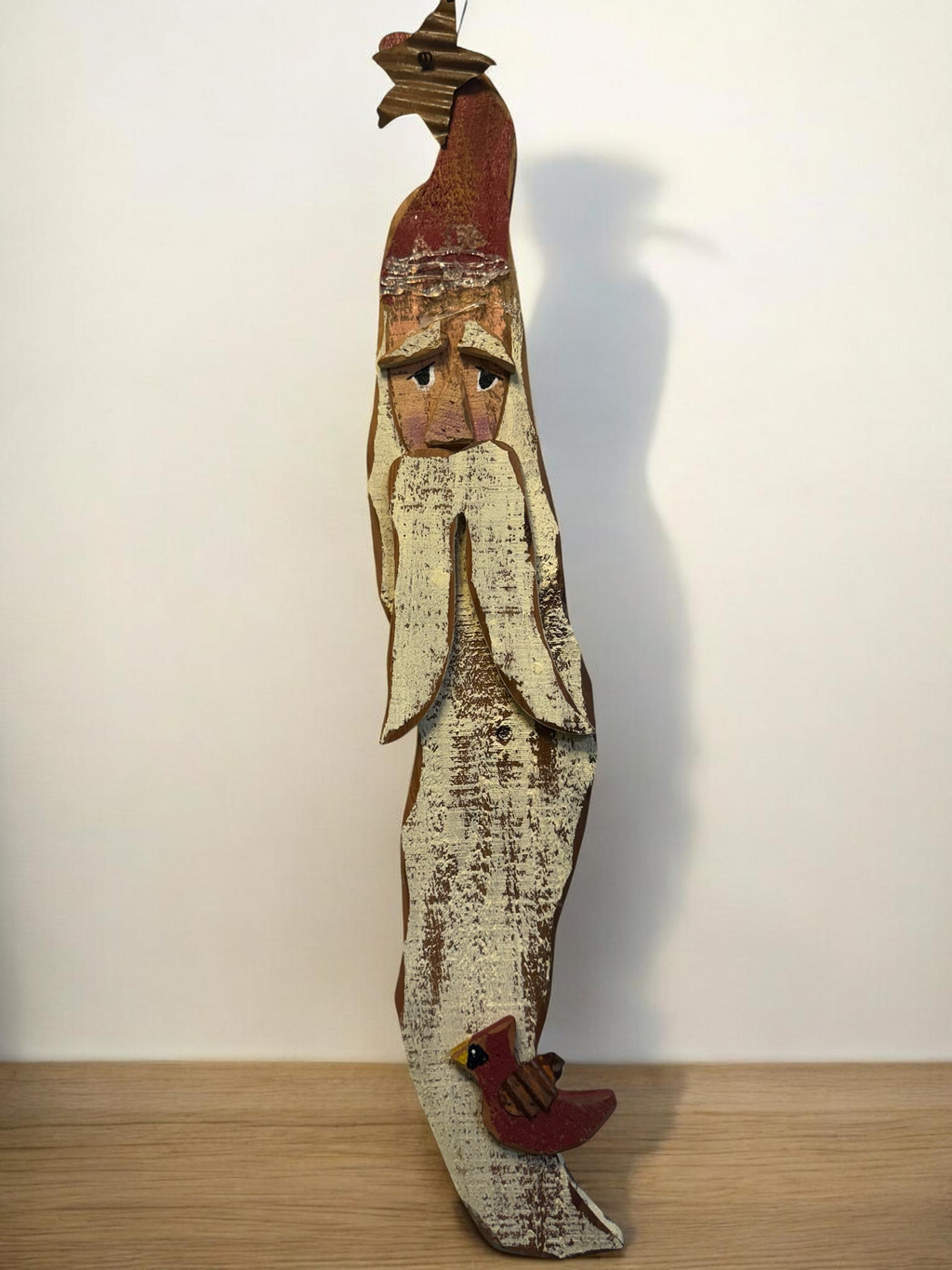 The Flip Side handcrafted wooden Santa Claus wall hanging with a distressed finish, red hat, and cardinal accent.