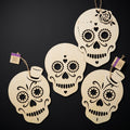 Unfinished laser-cut wooden sugar skull cutouts on solid matte dark black backdrop